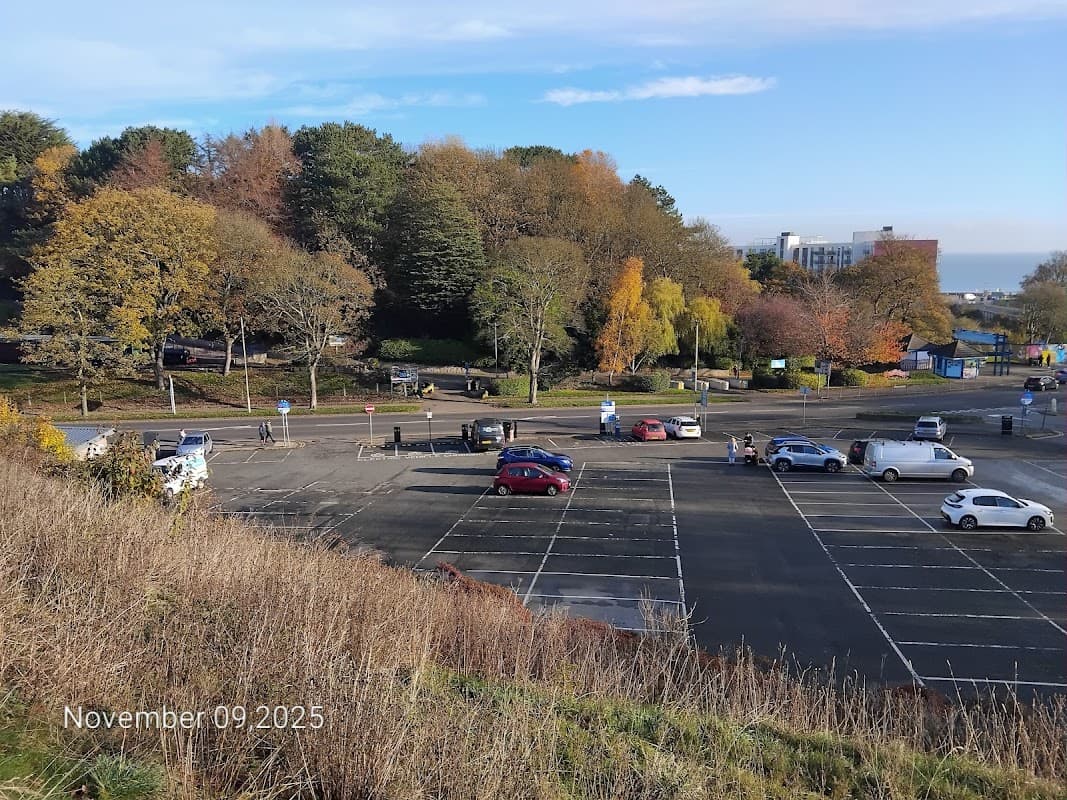 Northstead Lower Car Park in Scarborough, featuring empty parking spaces and autumn foliage under a clear blue sky.