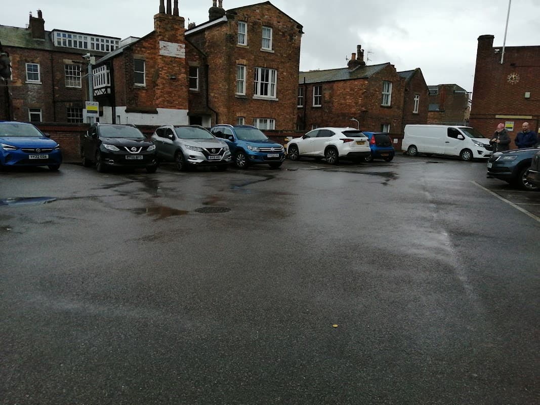 Somerset Terrace Car Park in Scarborough, featuring parked cars and brick buildings under a cloudy sky.