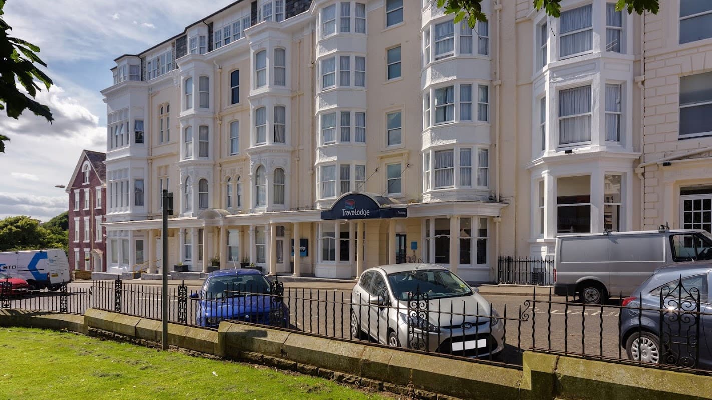 Travelodge Scarborough St Nicholas features a classic building facade, parked cars, and a landscaped area in front.