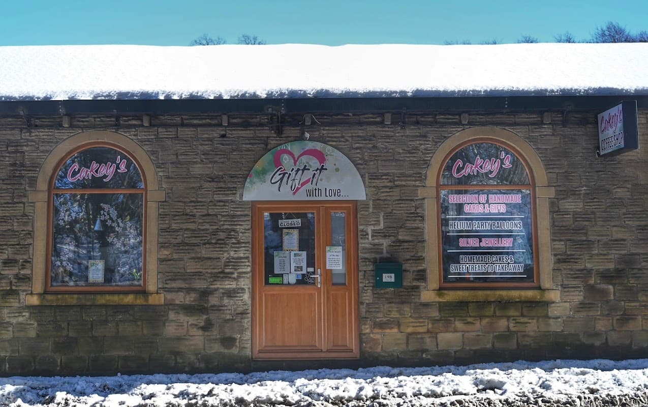 Cakey’s shop in Scissett, Yorkshire, featuring a snow-covered entrance and large windows with colorful signage.