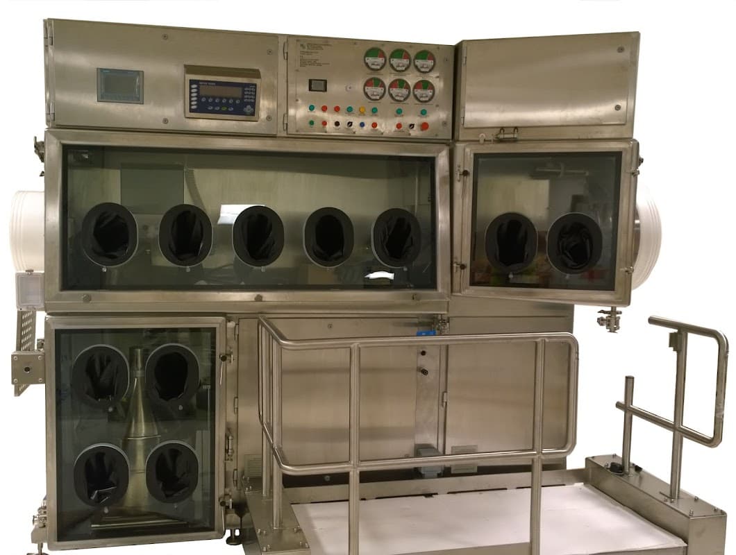 Stainless steel containment unit with multiple viewing ports and control panel, designed for handling hazardous materials.