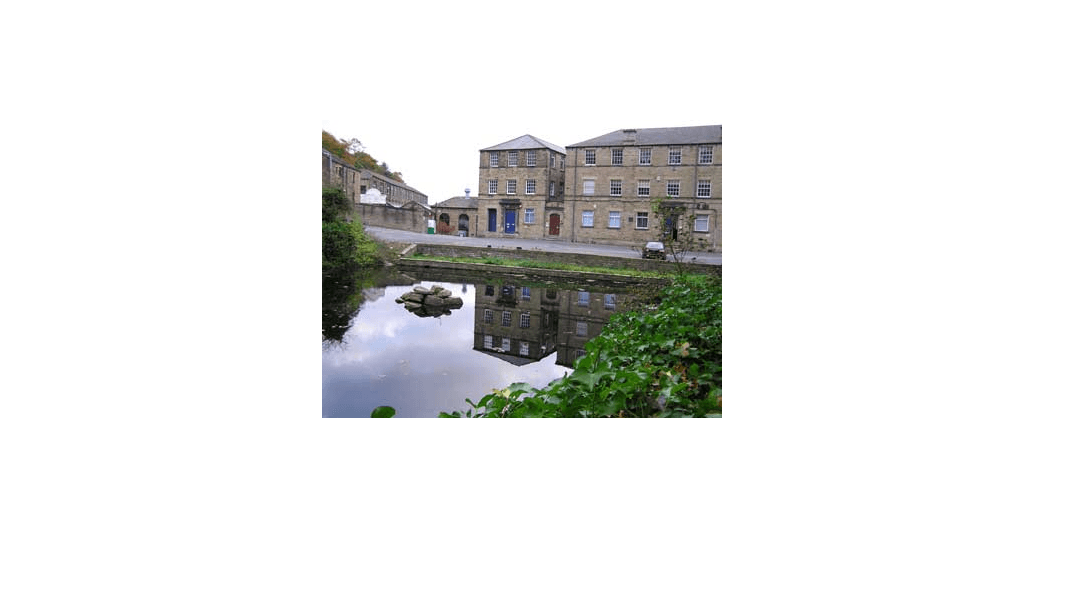 Nortonthorpe Industrial Park with stone buildings reflecting in still water, surrounded by greenery in Scissett, Yorkshire.