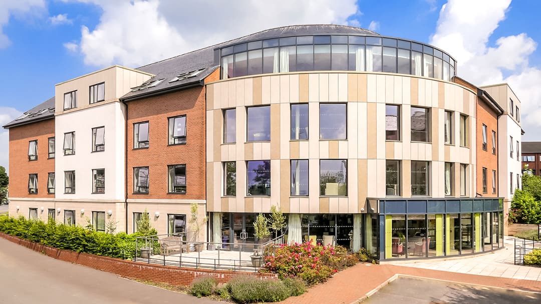 Modern care home building with large windows, landscaped gardens, and a paved entrance in Seacroft, Yorkshire.