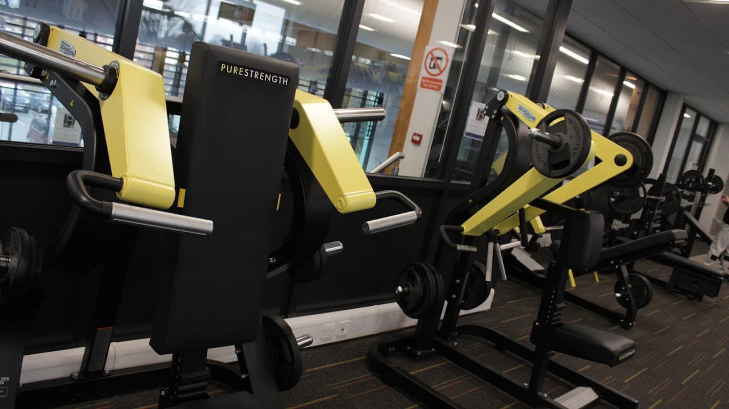 Gym equipment with yellow and black design, set against large windows at Selby Leisure Centre.