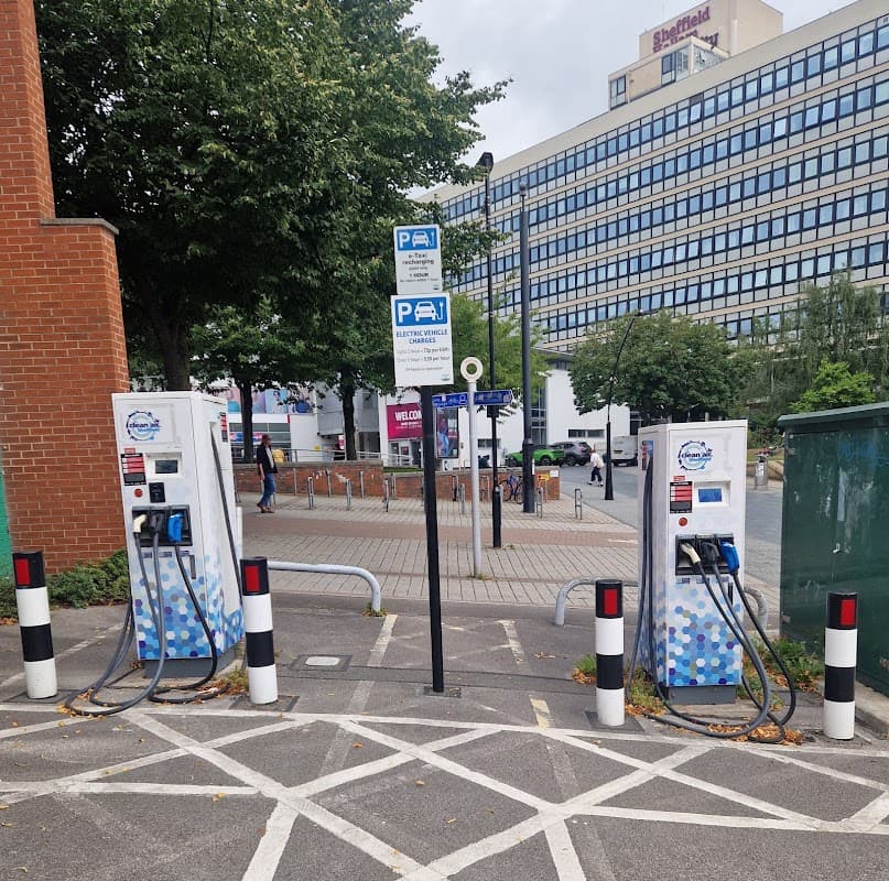 Pay & Display parking area with electric vehicle charging stations, signage, and surrounding greenery in Sheffield.
