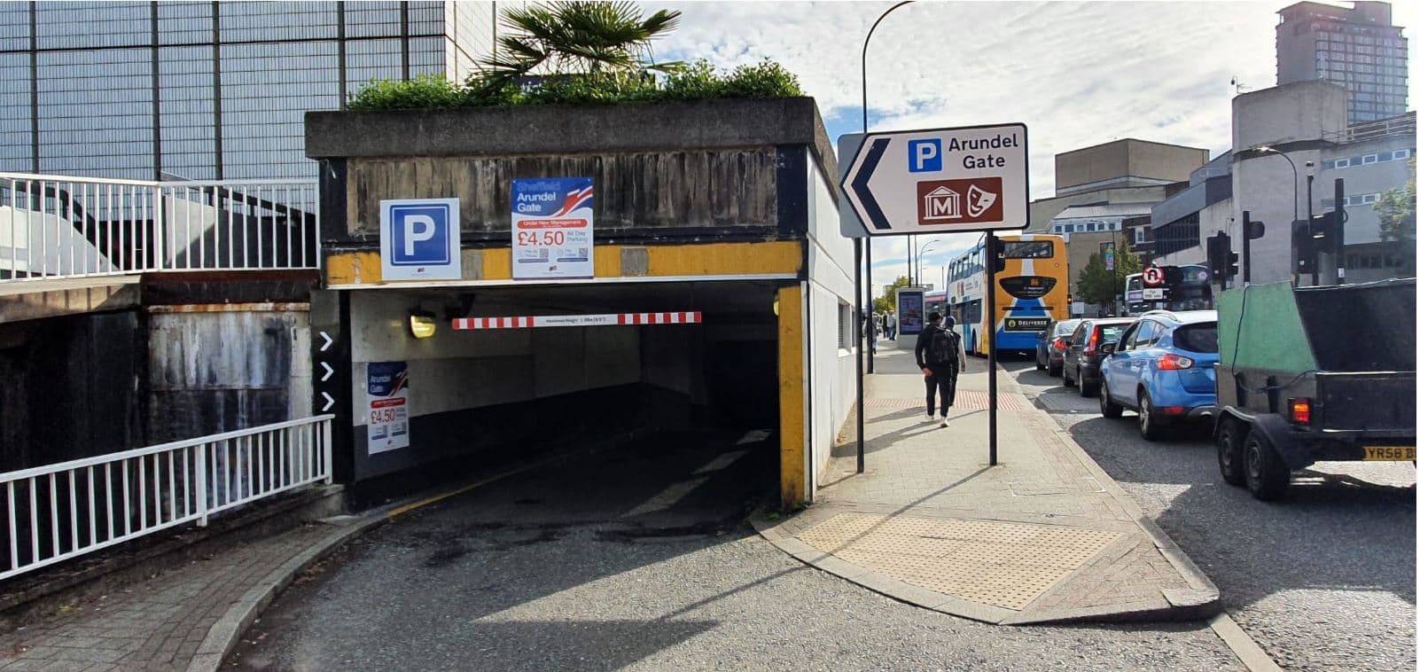 Entrance to Arundel Gate Car Park with signage, vehicles, and pedestrians along a busy street in Sheffield.