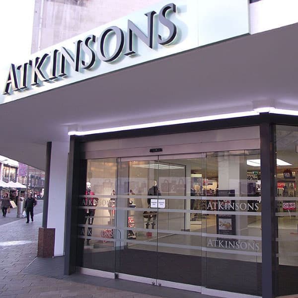 Atkinsons Department Store entrance with glass doors, modern signage, and shoppers visible outside in Sheffield, Yorkshire.