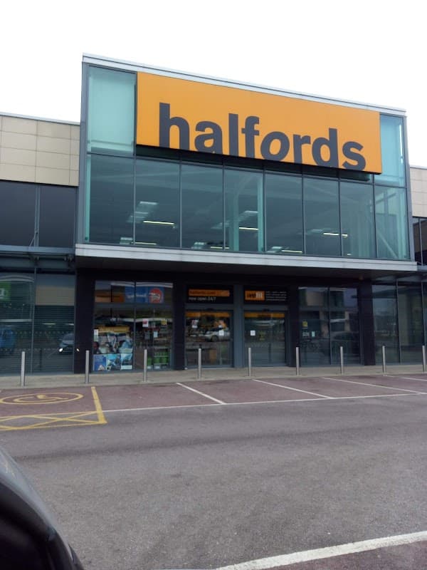 Halfords store front with large orange signage, glass entrance, and parking area in Sheffield, Yorkshire.