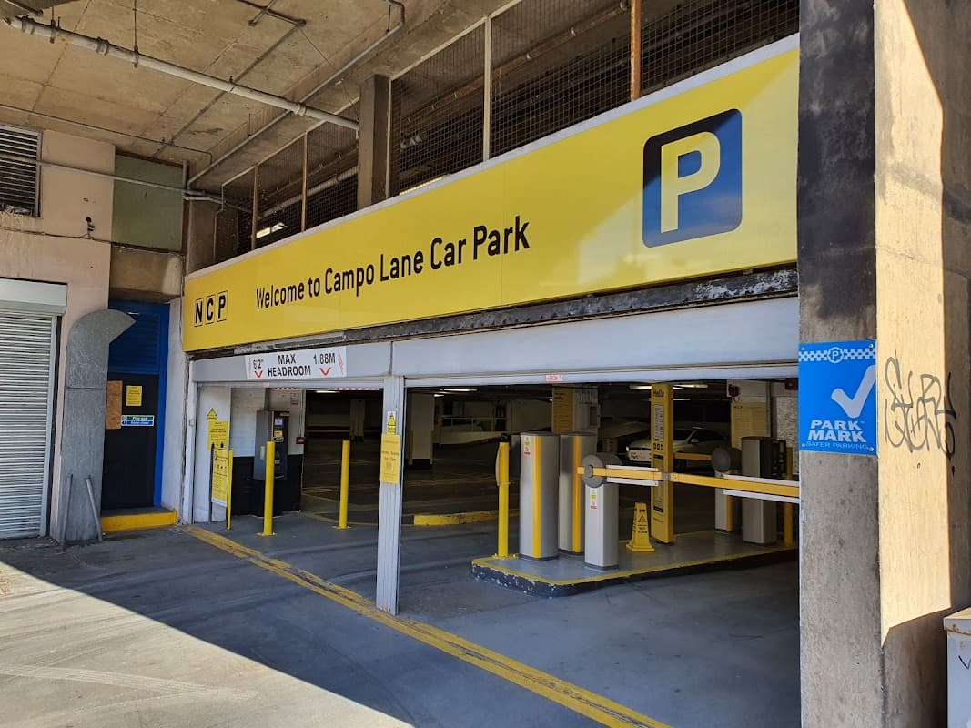 Welcome sign for Campo Lane Car Park with yellow background, parking symbols, and entrance barriers.