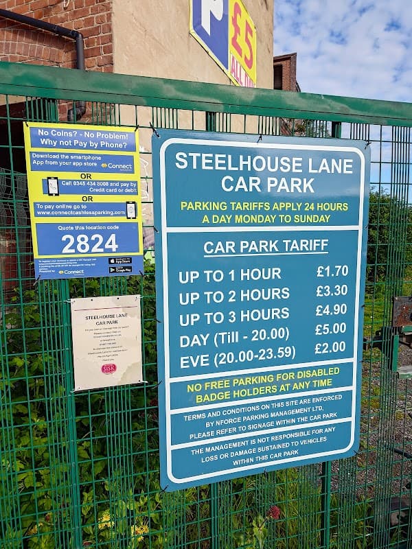 Signage detailing parking tariffs at Steelhouse Lane Car Park, Sheffield, with pricing for various durations displayed.