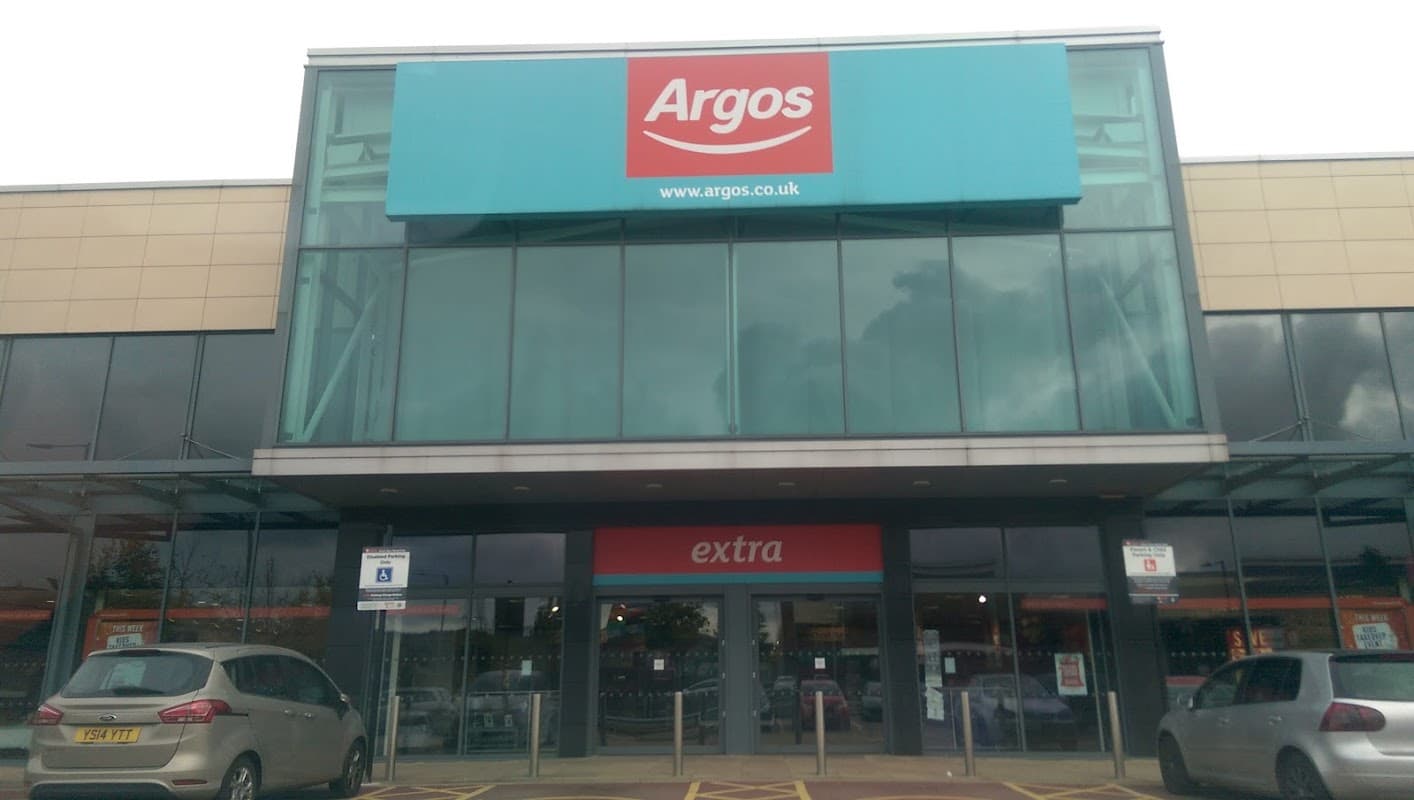 Argos store entrance with large blue signage, located inside Sainsbury's, featuring a modern glass facade.