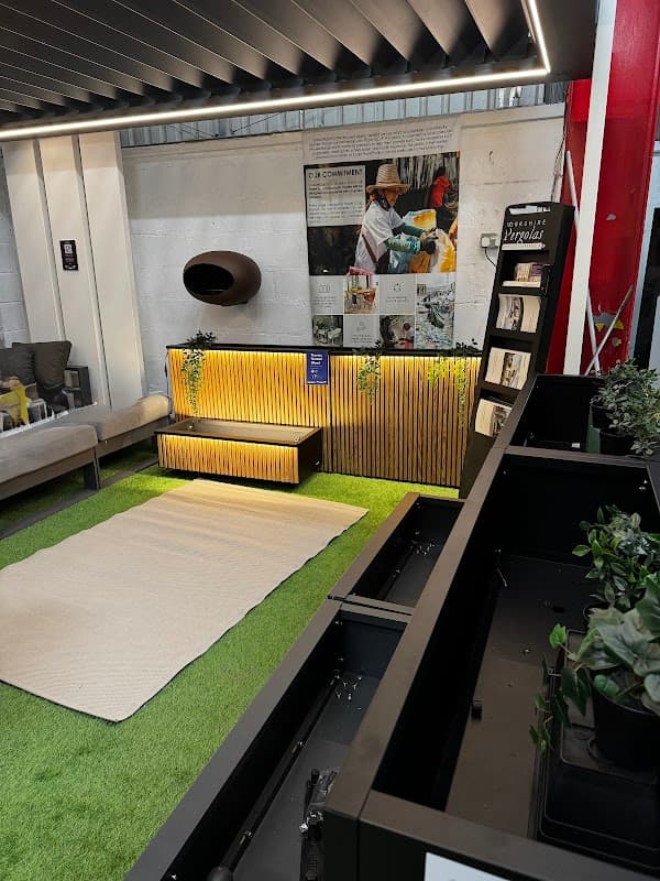 Modern showroom featuring stylish furniture, greenery, and a display with a wooden accent wall.