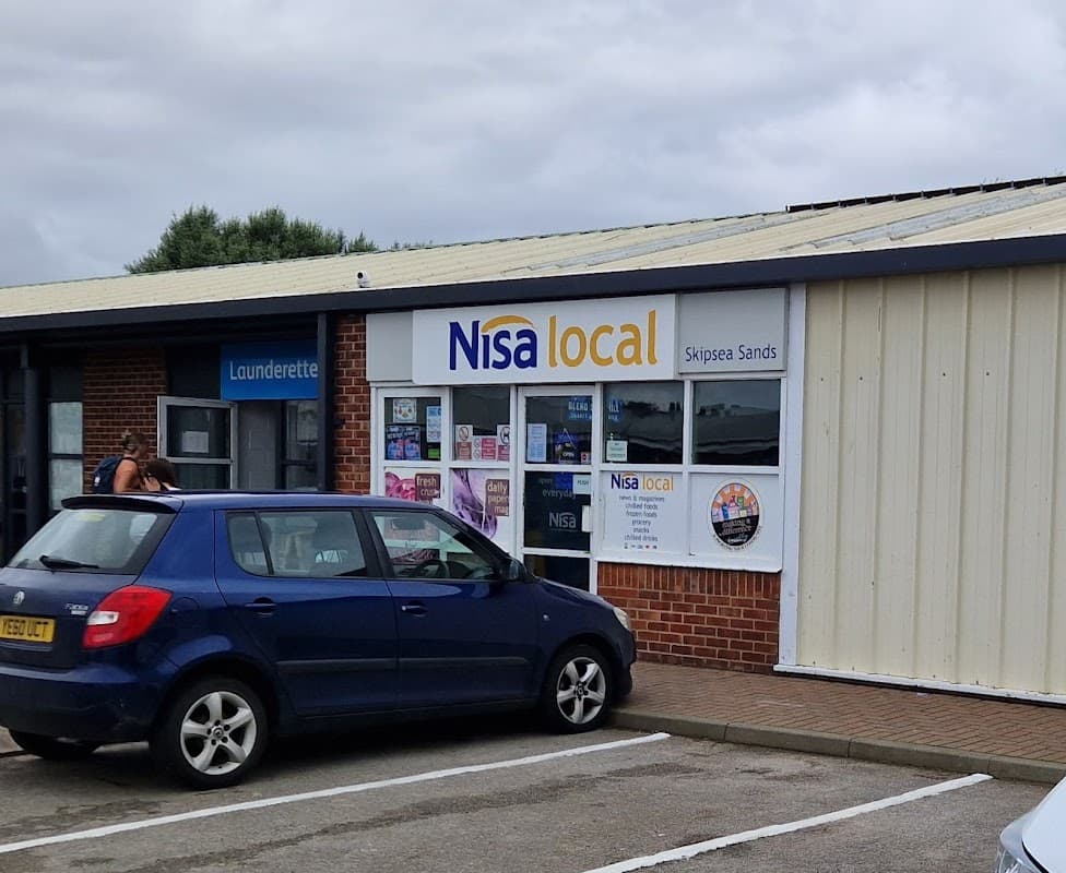 Nisa Local grocery store in Skipsea, Yorkshire, with a blue car parked outside and a laundrette nearby.