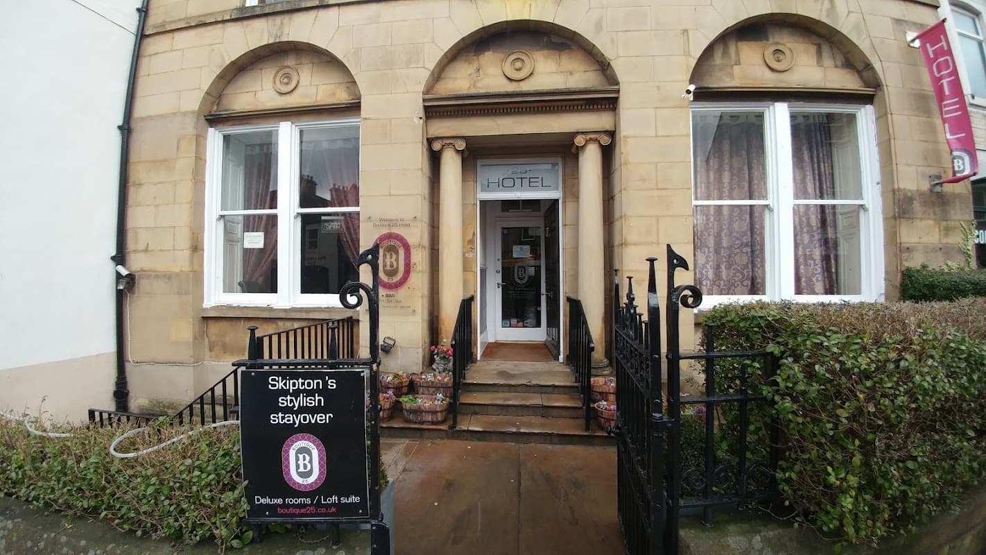Entrance of Boutique 25 bar with stone facade, large windows, and a sign promoting stylish stayovers.