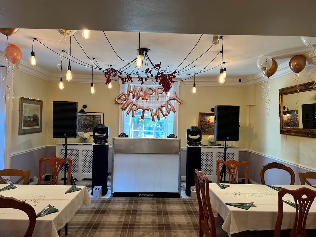 Interior of The Coachman Inn with tables set, a "Happy Birthday" sign, and festive decorations.