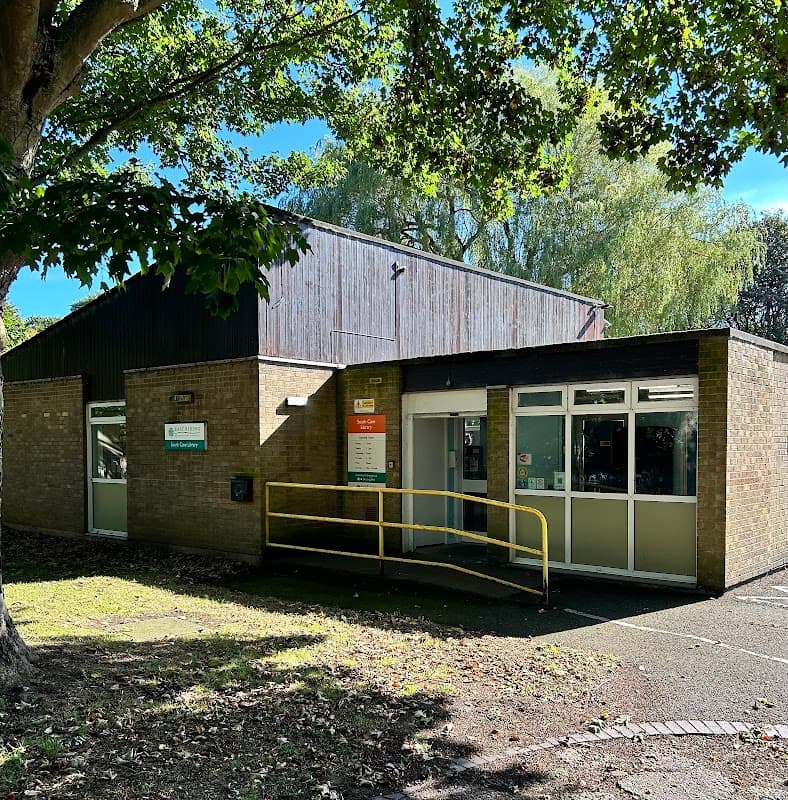 South Cave Library features a modern brick building with large windows and a yellow ramp for accessibility, surrounded by trees.