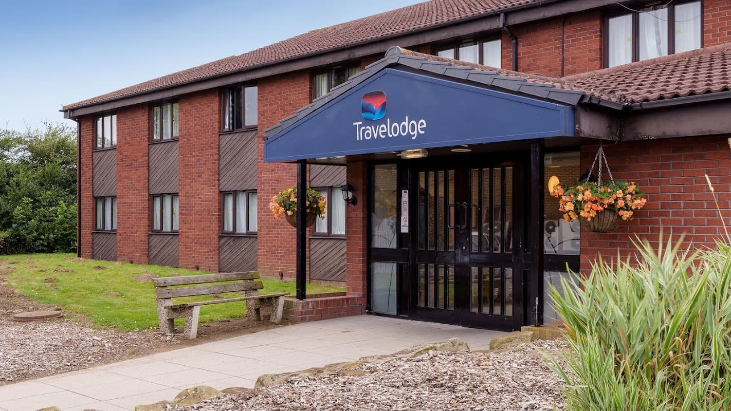 Exterior of Travelodge Hull South Cave with a welcoming entrance, flower baskets, and landscaped surroundings.