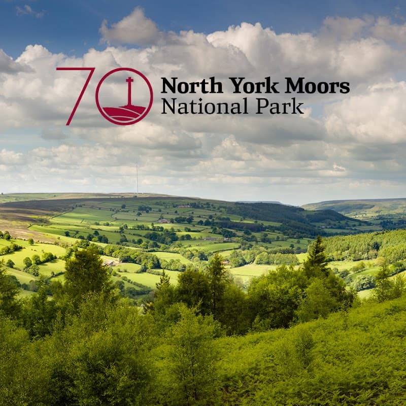 Lush green hills and valleys under a partly cloudy sky, with the North York Moors National Park logo overlay.