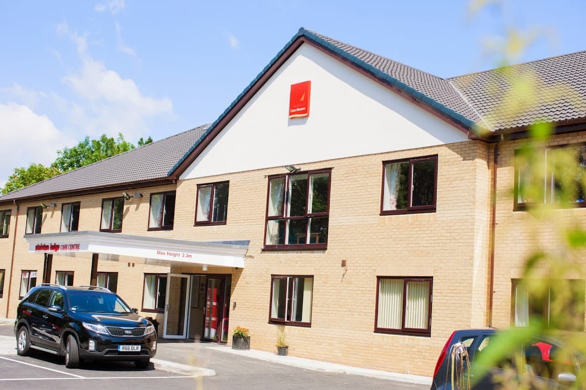 Stainton Lodge Care Centre with a modern facade, parking area, and clear blue sky in Stainton, Yorkshire.