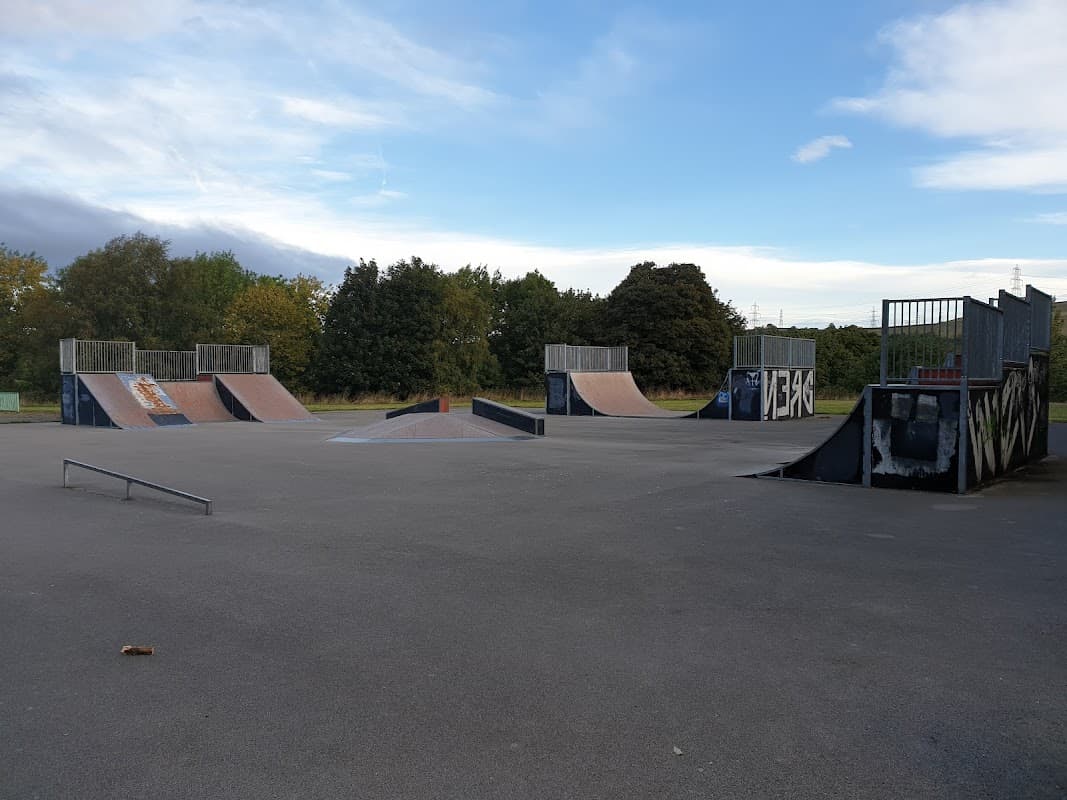 Skate park featuring ramps, a rail, and a spacious concrete area under a cloudy sky in Stocksbridge, Yorkshire.