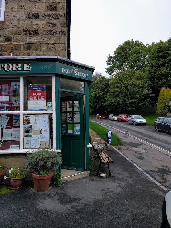 The Golden Lion restaurant entrance with a green door, potted plants, and a view of a quiet street lined with cars.