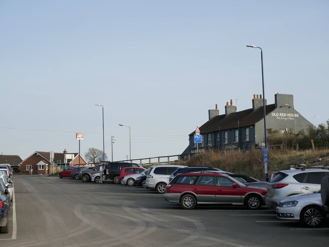 APCOA Parking at Thirsk Station with parked cars and the Old Red House pub in the background.