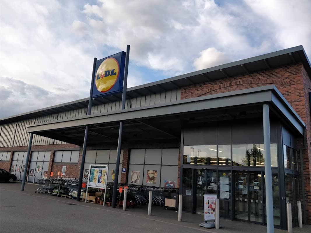 Lidl store entrance in Thirsk, Yorkshire, featuring a large sign and shopping carts outside.