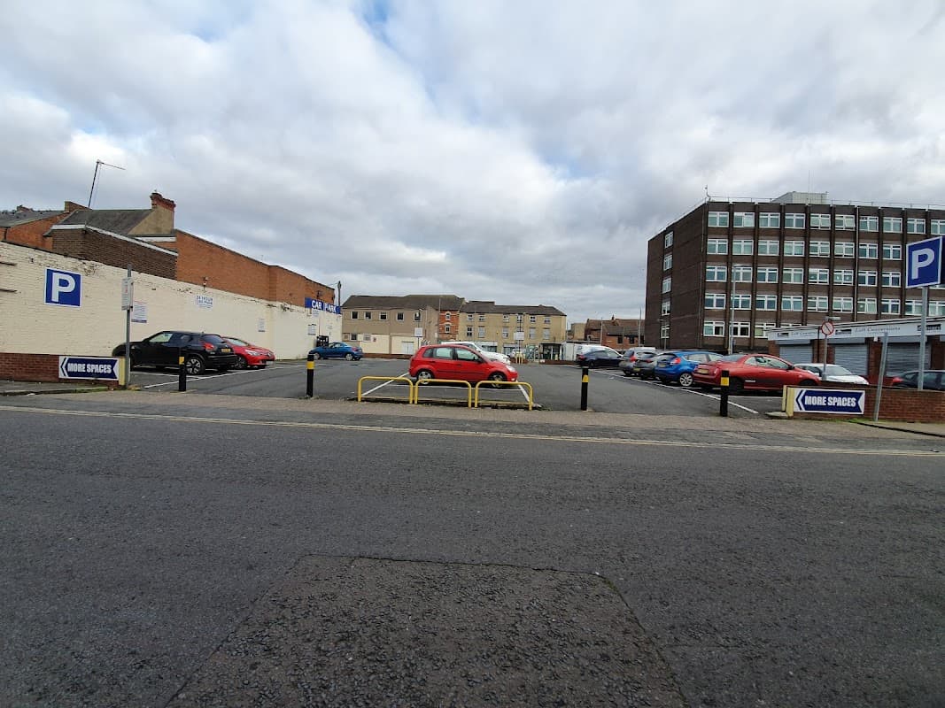 Brunswick Street Car Park with multiple parked cars and a sign indicating parking spaces, under a cloudy sky.