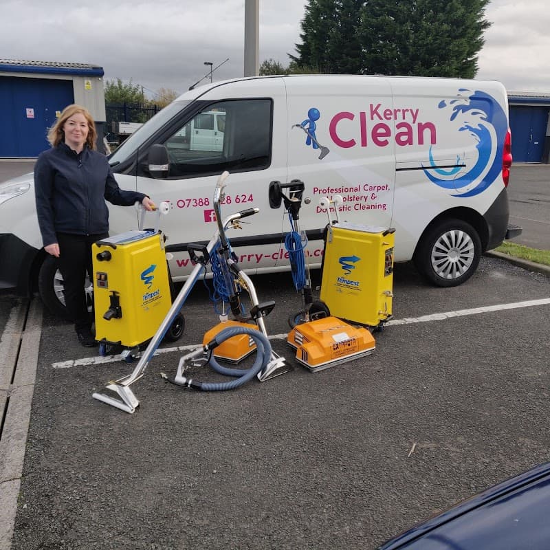 Woman standing beside a van with "Kerry Clean" logo, surrounded by cleaning equipment in a parking lot.