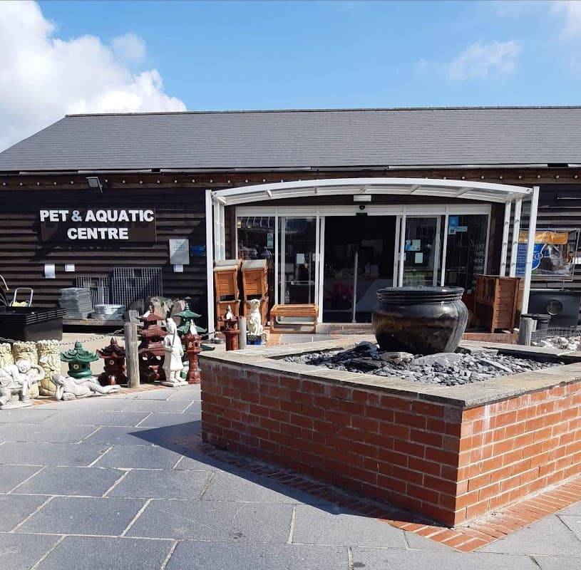Entrance of Wentworth Pet & Aquatic Centre with a stone fountain and decorative items outside.