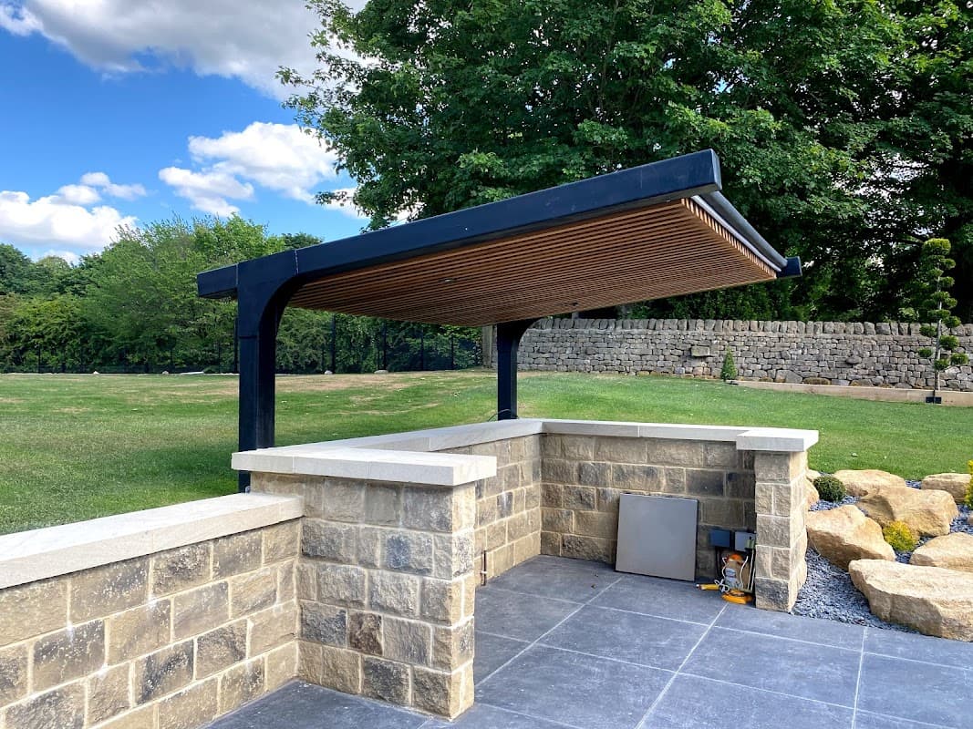 Pay & Display parking area with a modern shelter, stone walls, and a landscaped green space in West Tanfield, Yorkshire.