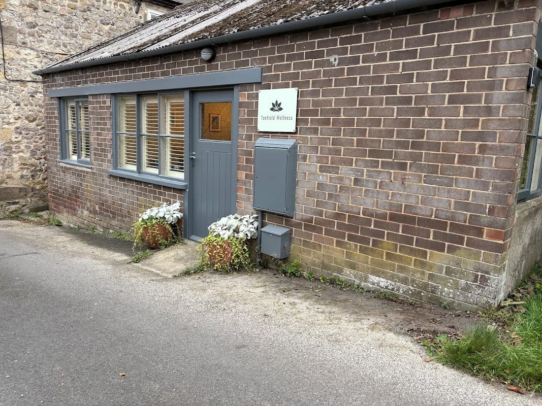 Biodynamic craniosacral therapy clinic with brick exterior, gray door, and potted plants in West Tanfield, Yorkshire.