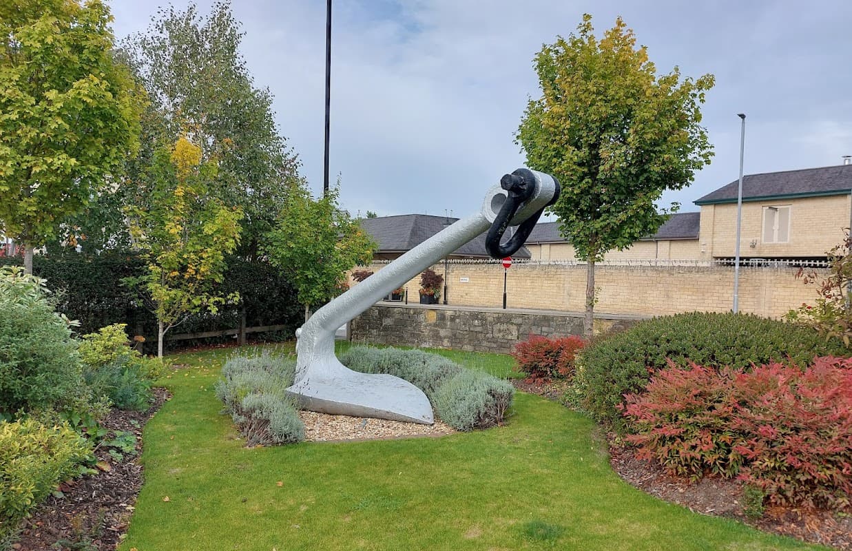 Large anchor sculpture surrounded by greenery and shrubs in a landscaped area near Car Parks in Wetherby, Yorkshire.