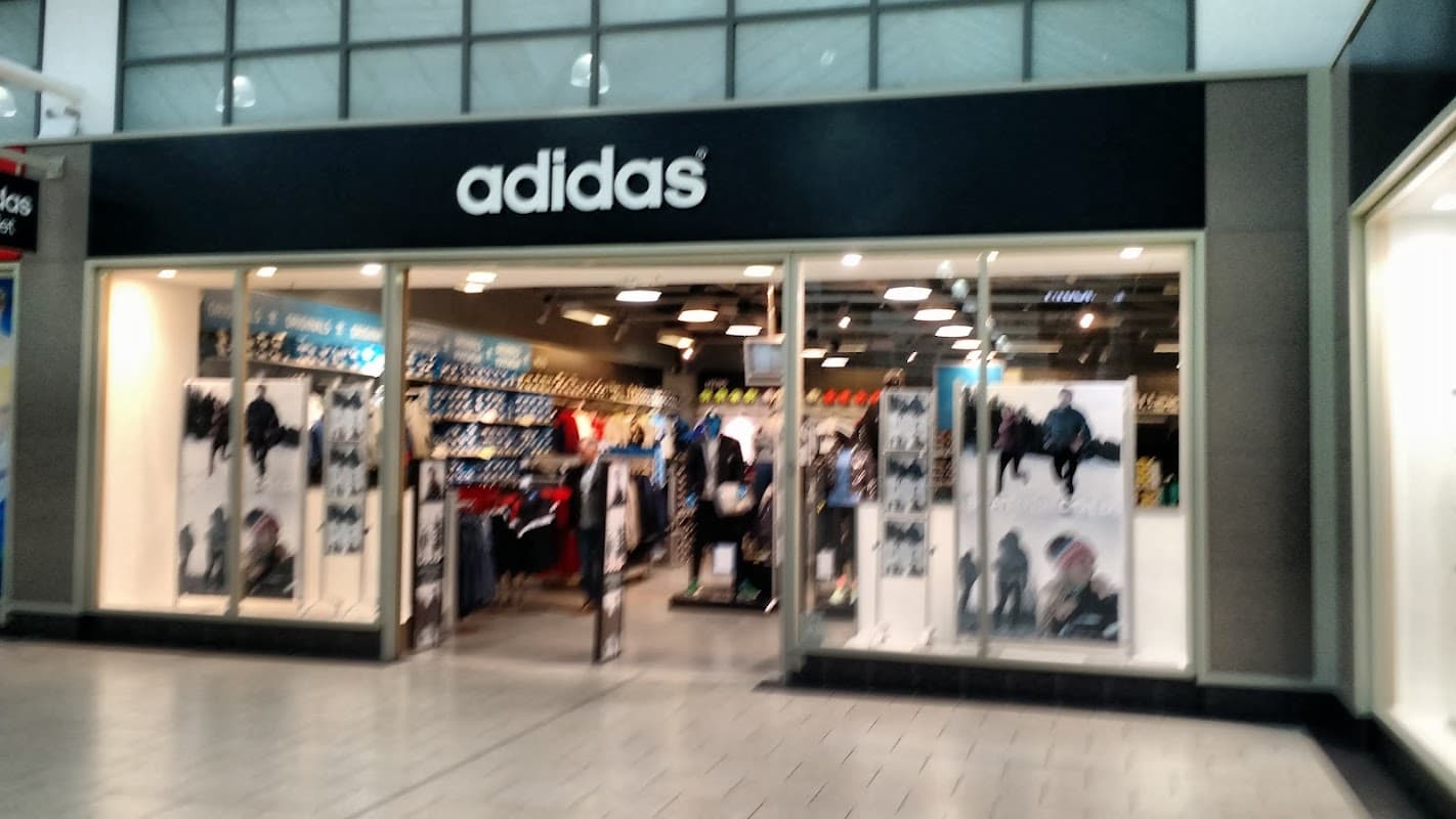 Adidas outlet store entrance in York, featuring athletic apparel and footwear displayed prominently in the windows.