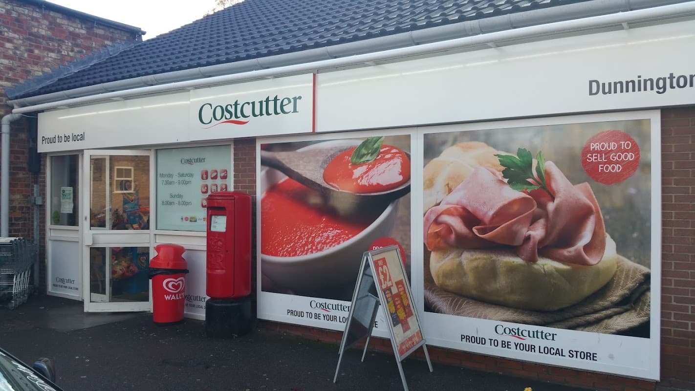 Costcutter storefront featuring vibrant food imagery, a red post box, and a welcoming entrance in Dunnington, York.