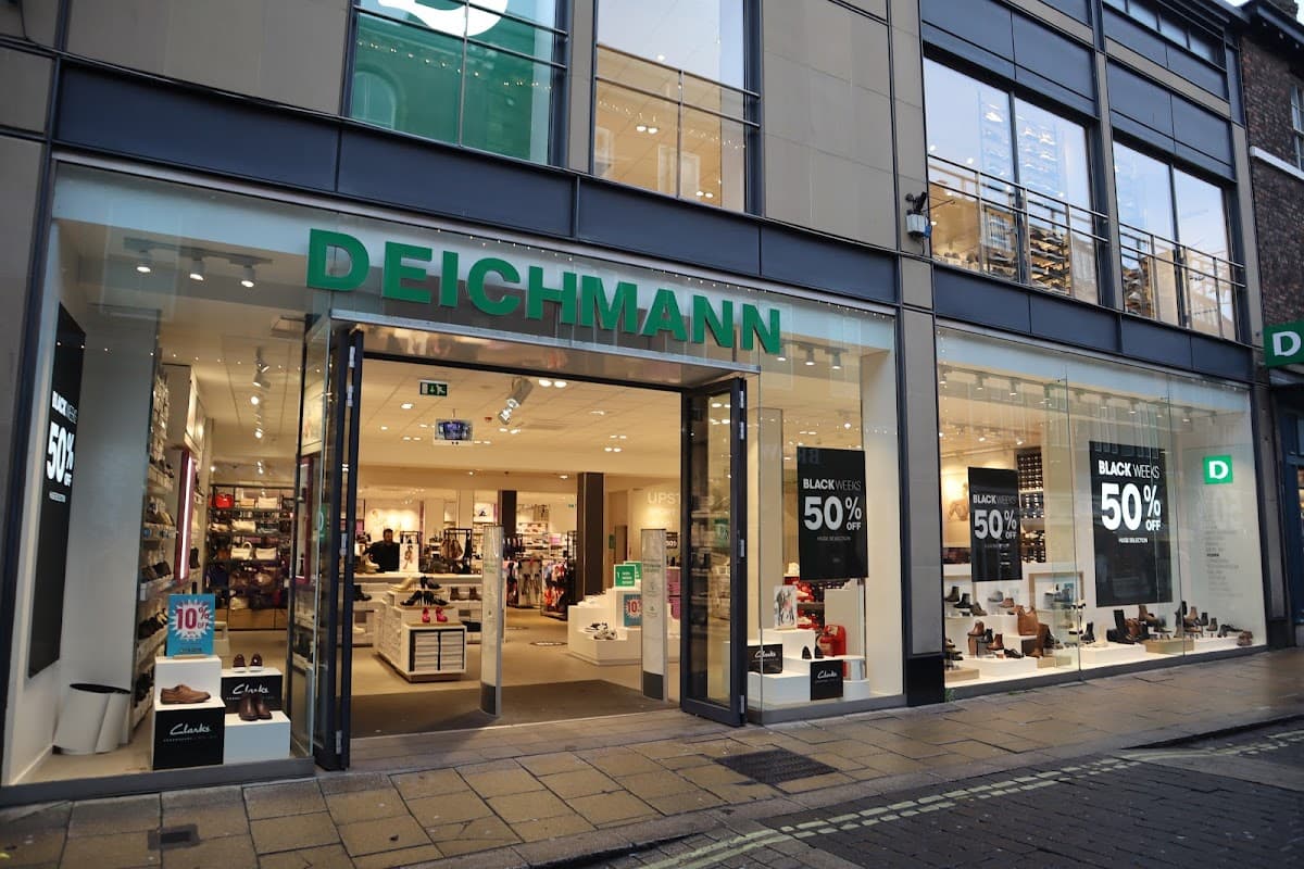 DEICHMANN shoe shop with large glass entrance, sale signs, and various shoe displays inside.