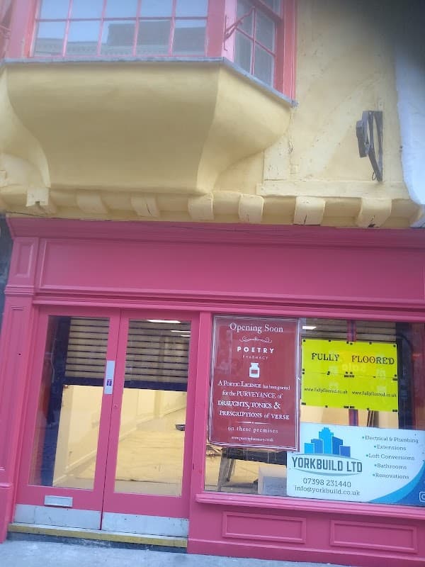 Bright pink storefront with large windows displaying "FULLY FLOORED" and "Opening Soon" signs in York, Yorkshire.