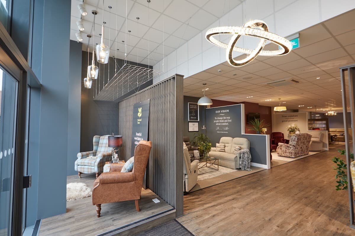 Stylish furniture display with armchairs, sofas, and modern lighting in a spacious showroom.