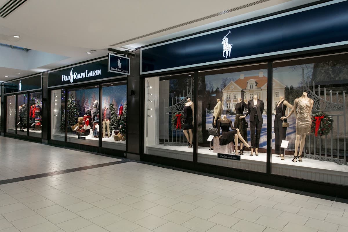 Polo Ralph Lauren Outlet with festive window displays featuring mannequins in stylish clothing and holiday decorations.