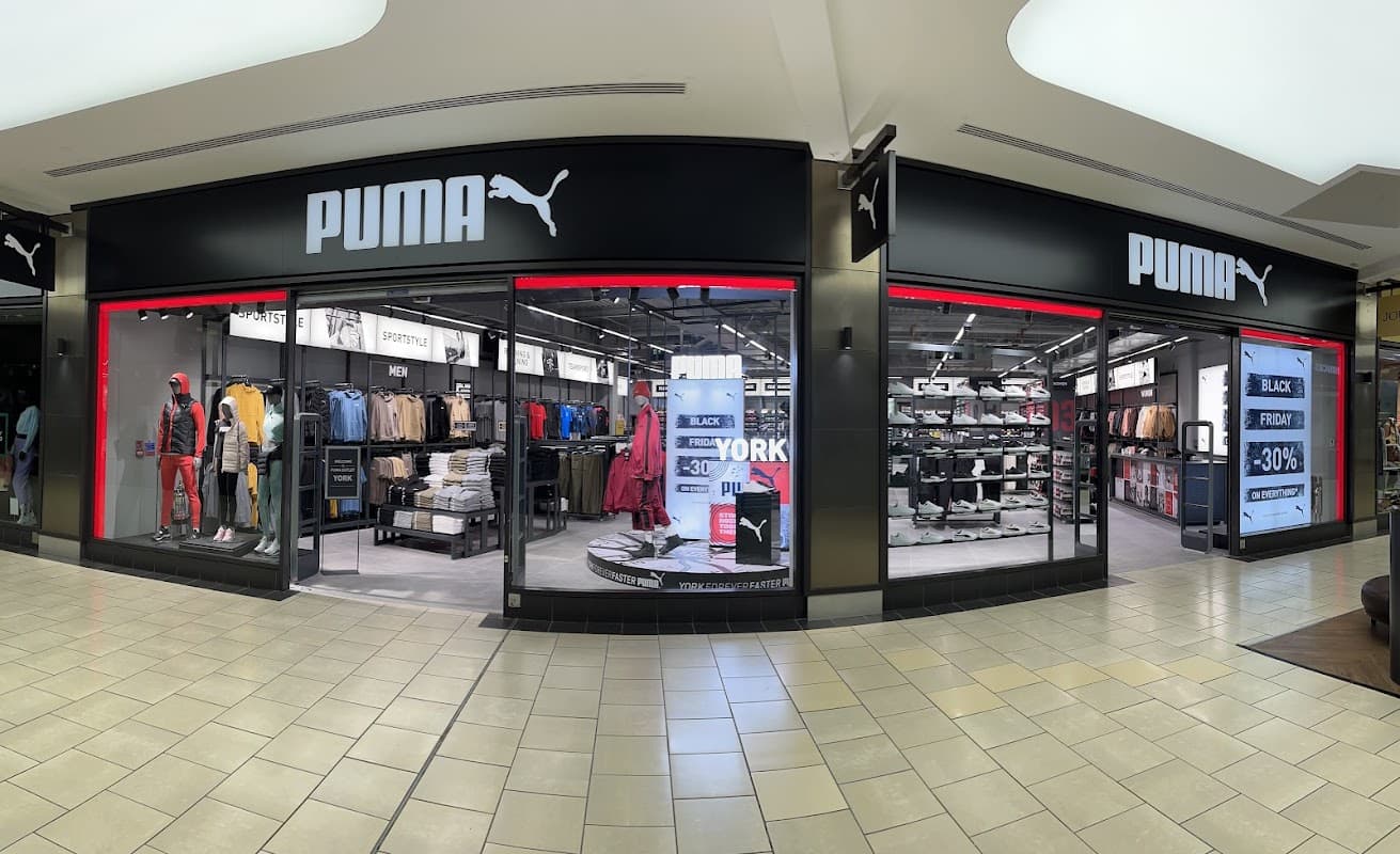 PUMA Outlet in York featuring sportswear, shoes, and promotional signage in a modern retail setting.