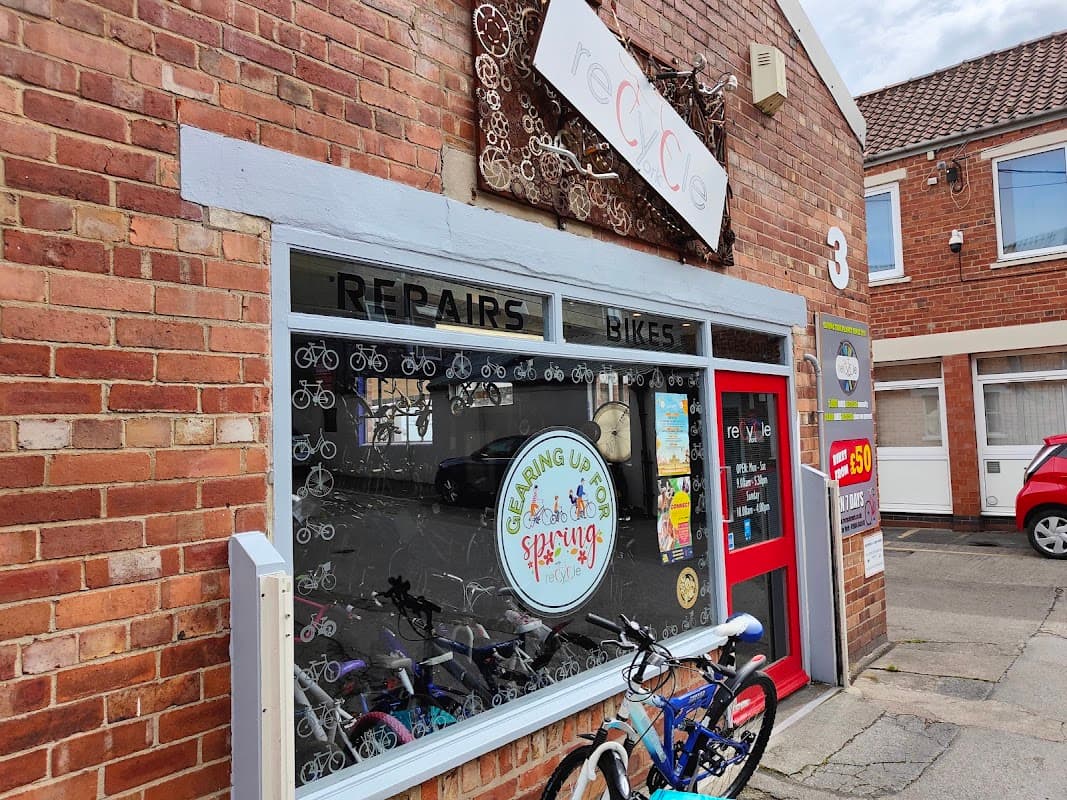 Brick storefront with "REPAIRS BIKES" signage, bicycle-themed decor, and colorful bikes outside.