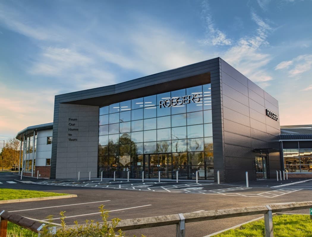 Modern storefront of Rodgers Of York Ltd, featuring large glass windows and a sleek design against a clear sky.