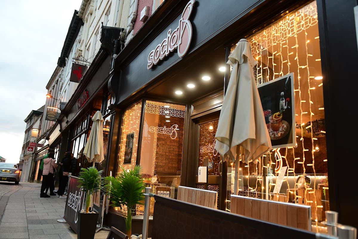 Cozy pub entrance with warm lighting, outdoor seating, and decorative plants in York, Yorkshire.