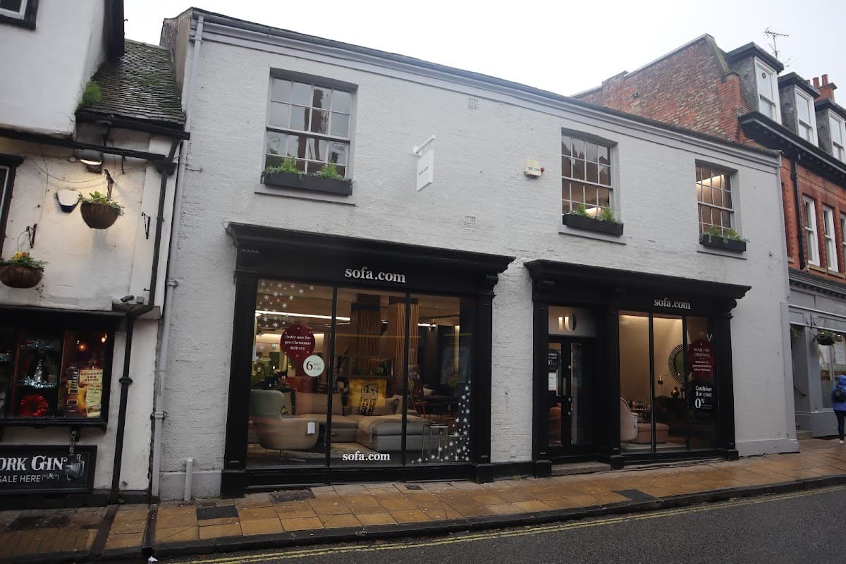 Two-story furniture shop with large windows displaying sofas, located on a cobbled street in York, Yorkshire.
