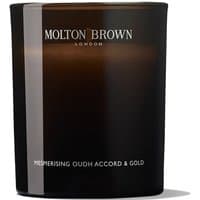 Dark brown Molton Brown candle with white text, labeled "Oudh Accord & Gold," in a sleek glass container.