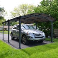 Gray Palram Canopia Arcadia 5000 metal carport with arched roof and sturdy black frame, sheltering a parked car.
