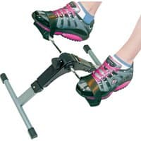 Compact pedal exerciser with digital display, silver frame, black pedals, and adjustable tension knob.