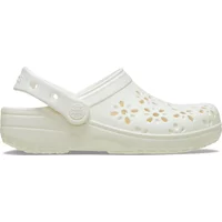 White Crocs Classic clogs with floral cut-out design and adjustable heel strap.