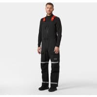 Black Helly Hansen Arctic Patrol pants with suspenders, reflective stripes, and orange shoulder accents, size S.