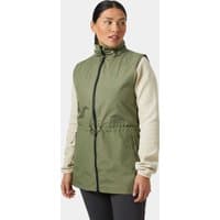 Green Helly Hansen women's spring vest with high collar, black zipper, and adjustable waist, worn over beige sleeves.